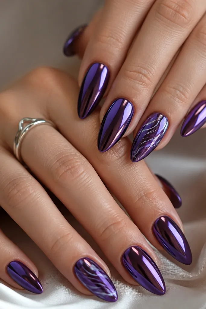 Almond nails with dark purple mirror chrome on most nails. One or two accent nails have a swirl marble pattern in deeper purple and silver chrome lines.