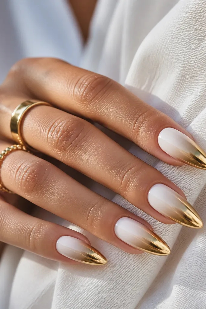 Each nail fades from bright white near the base into a smooth transition toward gold chrome at the tips. The center looks lighter and smoky, with a clear mirror gold area at the very end.