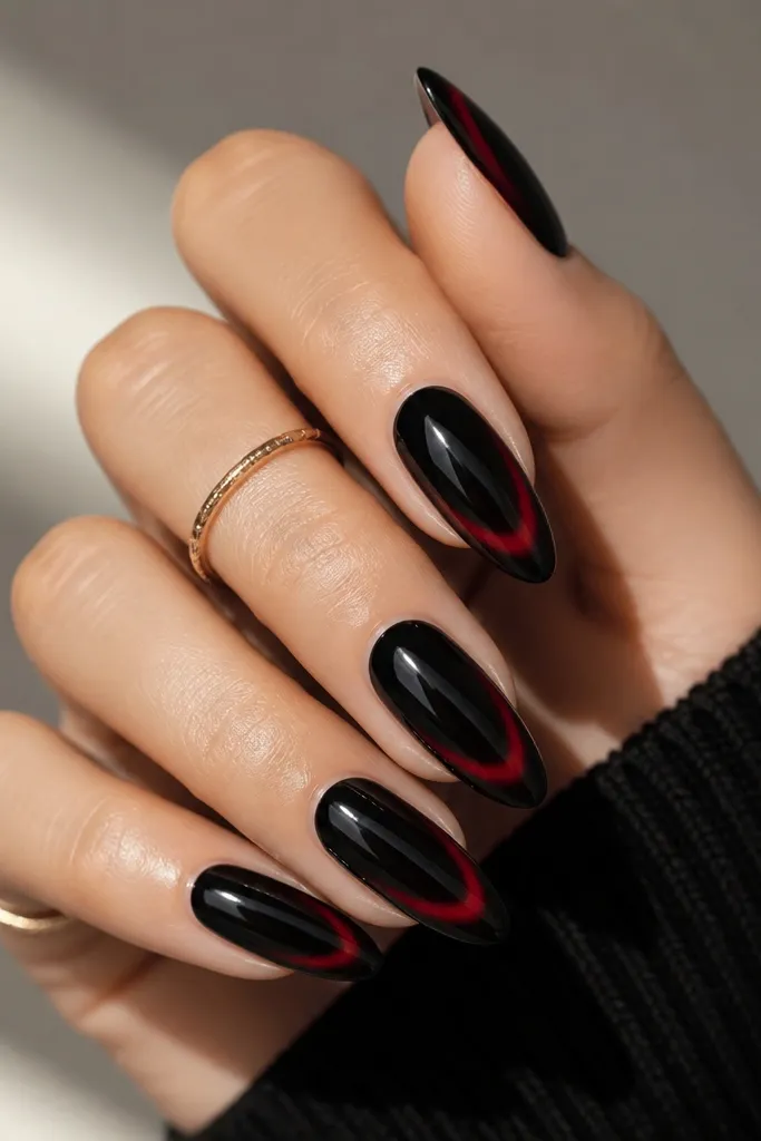 Almond nails with a black base and a red aura ring near the tip. The very edge looks crisp and the red halo sits like a French tip glow under a clear top coat.