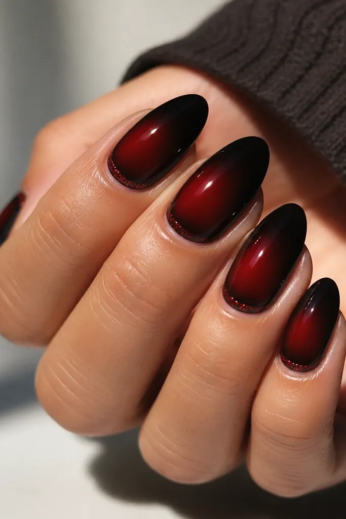 Black nails with a soft red aura centered, plus a thin line of micro red glitter near the sidewalls. High gloss top coat.