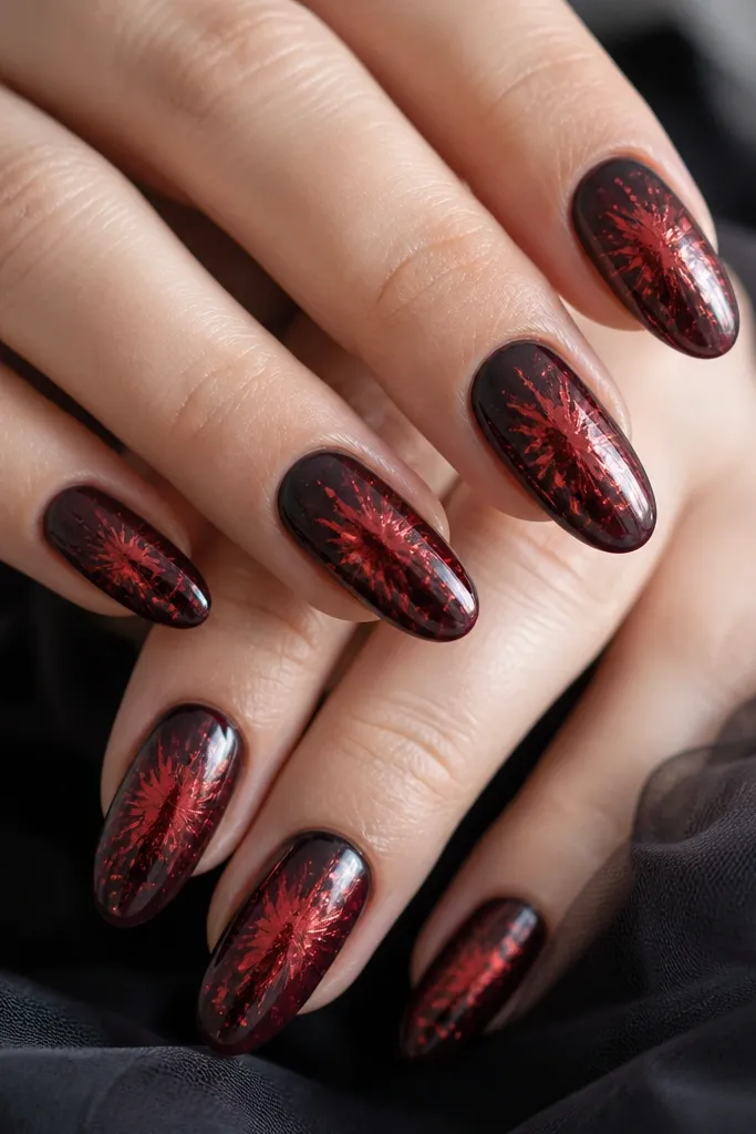 Black nails with red aura glow in the center and small red foil pieces fanned outward like flares. Glossy finish over foil.