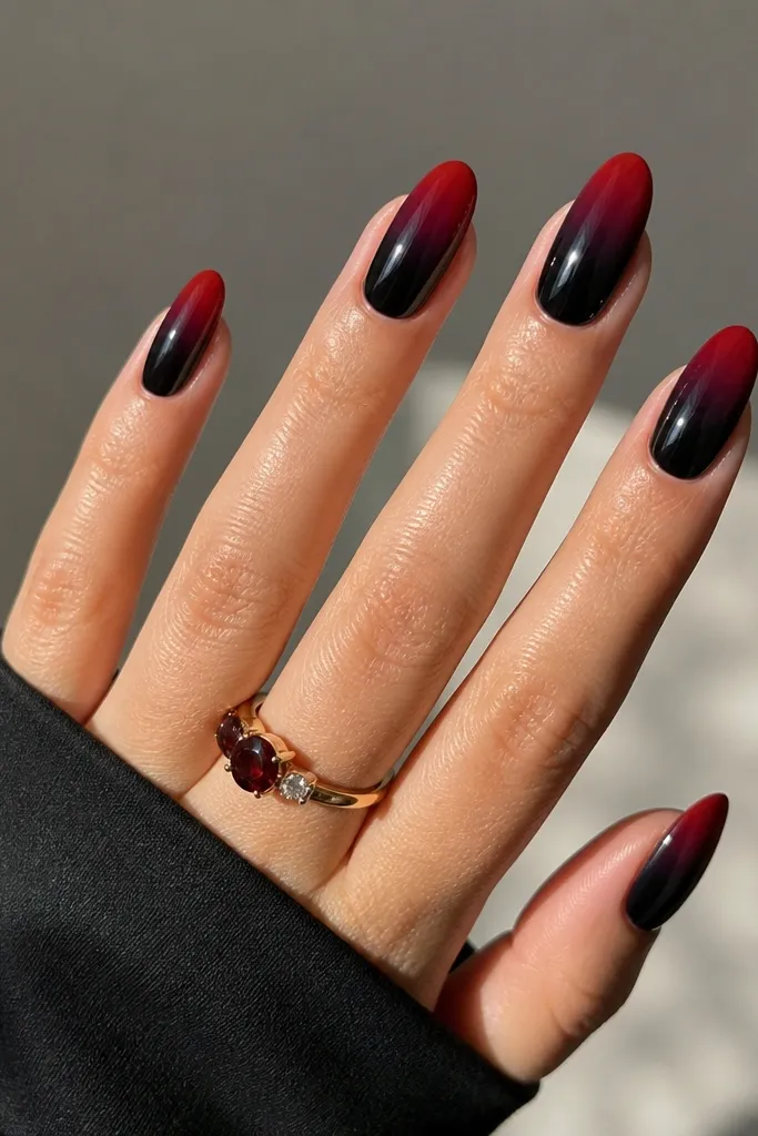 Nails show red aura tips that fade into black mid-nail, with the softest red halo at the very top near the tip. Glossy finish.