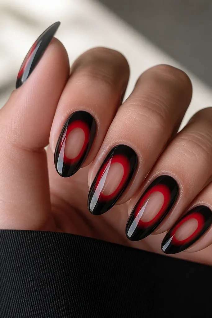 Nails have a negative space window in the center with a red aura glow behind it, while the rest is black. The clear window stays clean with glossy top coat.