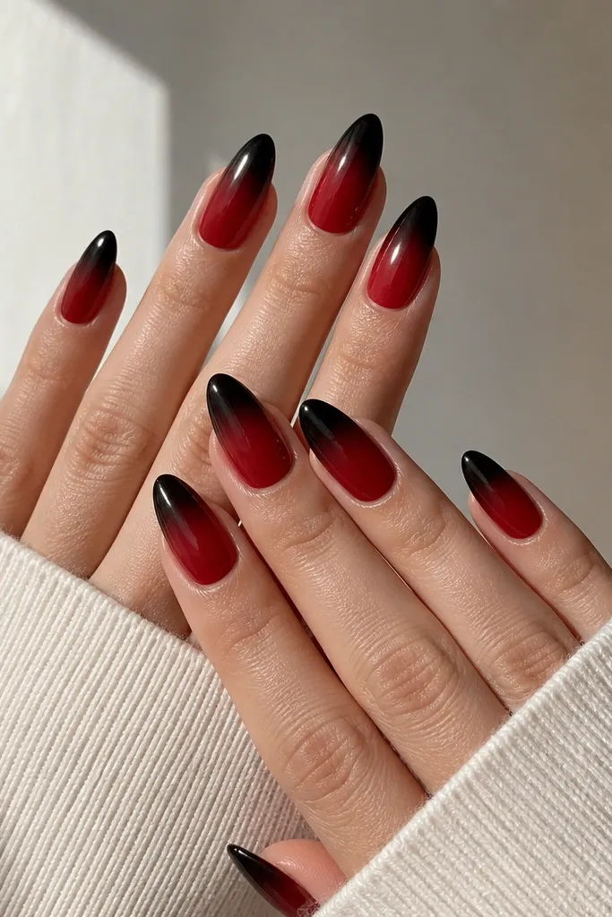 Ten nails in glossy almond shape; each nail shows black at the very tip fading into cherry red toward the middle, with a clean, smooth gradient and no extra gems.