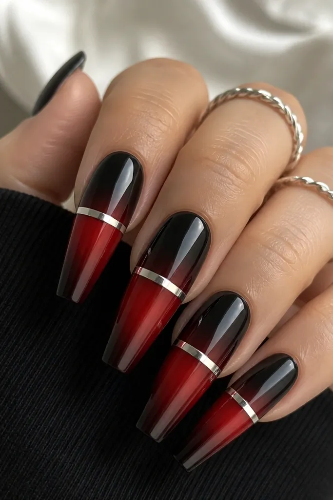 Long coffin nails; black-to-red ombre runs from tip to mid-nail, and a thin silver chrome stripe crosses horizontally near the center with a mirror shine.
