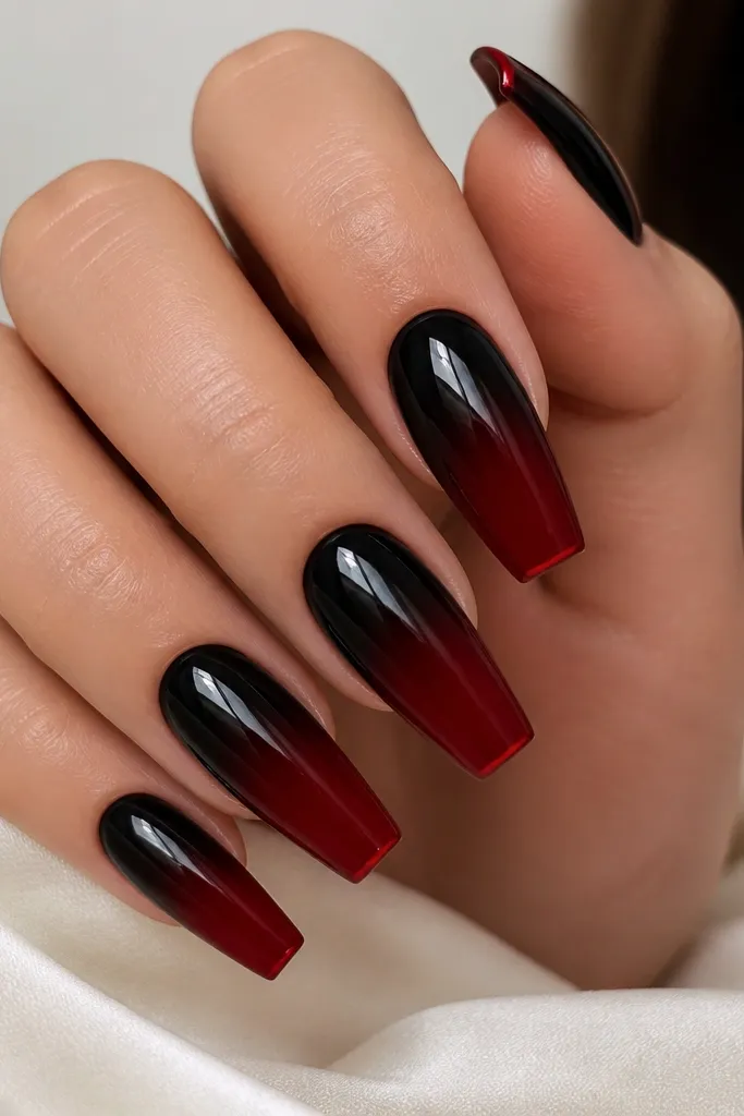 Coffin nails where black fades into red, plus one thin red accent line at the very tip on each nail; the accent looks like a tiny skittle stripe.