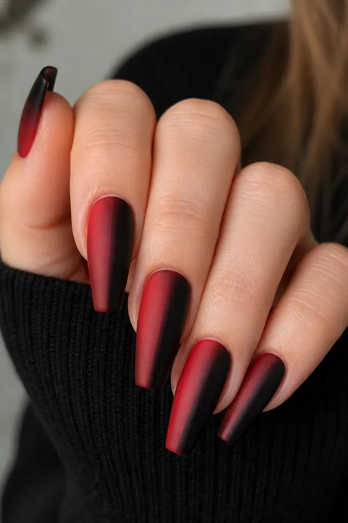 Coffin nails with a centered vertical ombre blend; left half fades from black into red, right half fades from red into black, meeting in a soft center line.