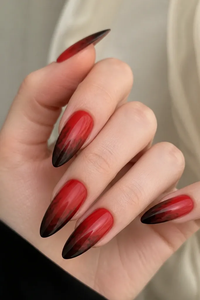 Long almond nails; red ombre base with a soft black smoke veil drifting in from the sides and fading into the red at mid-nail.