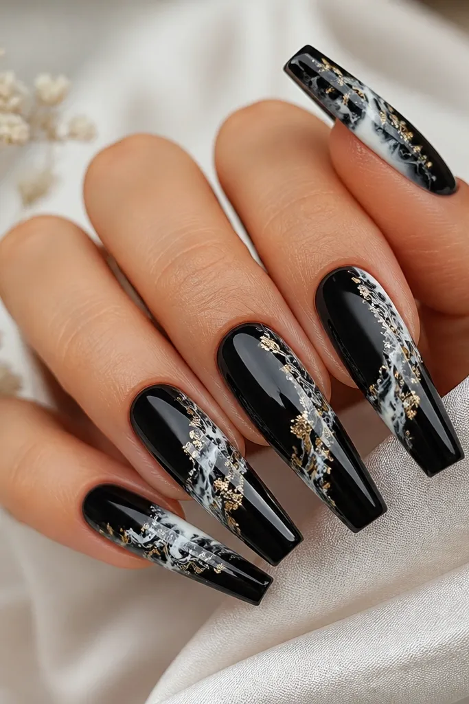 Long coffin nails with a glossy black base. White marble swirls run through the center and tips, with thin gold leaf flecks scattered irregularly near the swirl edges.