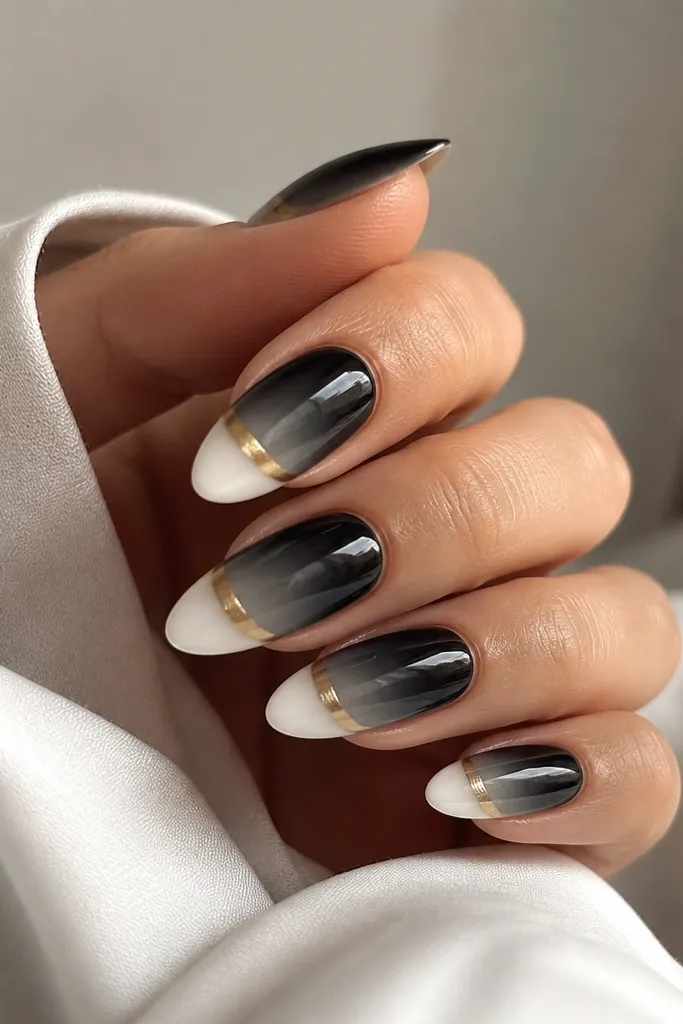 Medium almond nails with a smooth black-to-gray ombre fading into bright white at the tips. Along the ombre line there's a gold chrome band that looks like a thin halo.