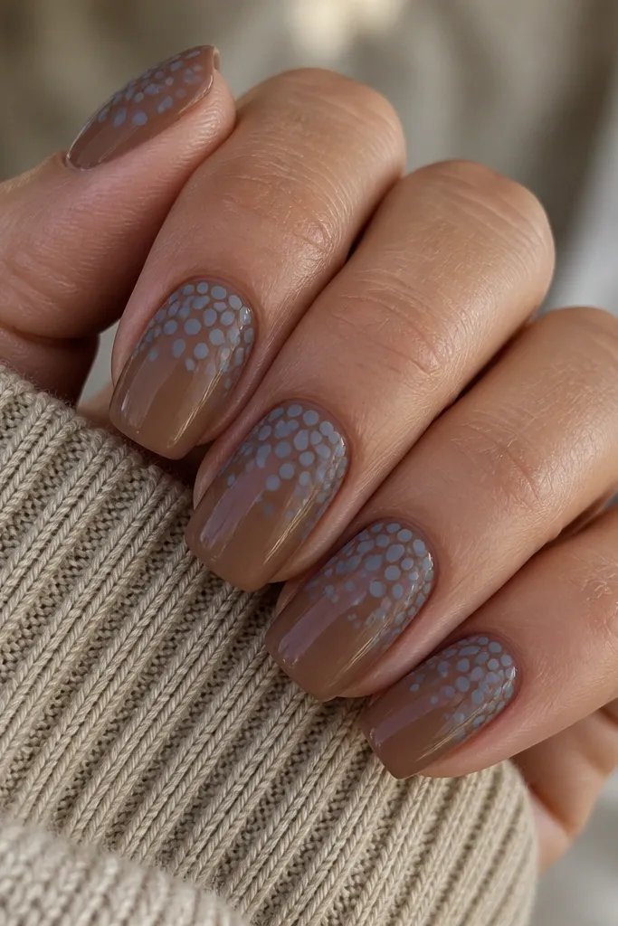 Medium squoval nails with an espresso-brown nude base. The top half is covered in evenly scattered matte dusty periwinkle dots. The dots vary slightly in size, and the rest of the nail stays glossy nude-brown with no other accents.