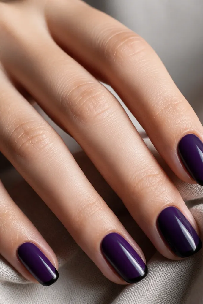 Five nails painted deep velvet purple; the tips are thin black lines like micro-French, with a glossy top coat that makes the purple look plush and the black look razor-sharp.