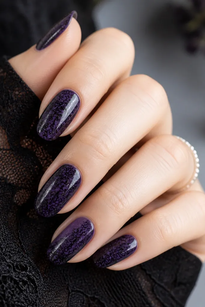 Dark purple nails with a repeating black lace pattern stamped across the surface; the lace has fine lines and a glossy finish.