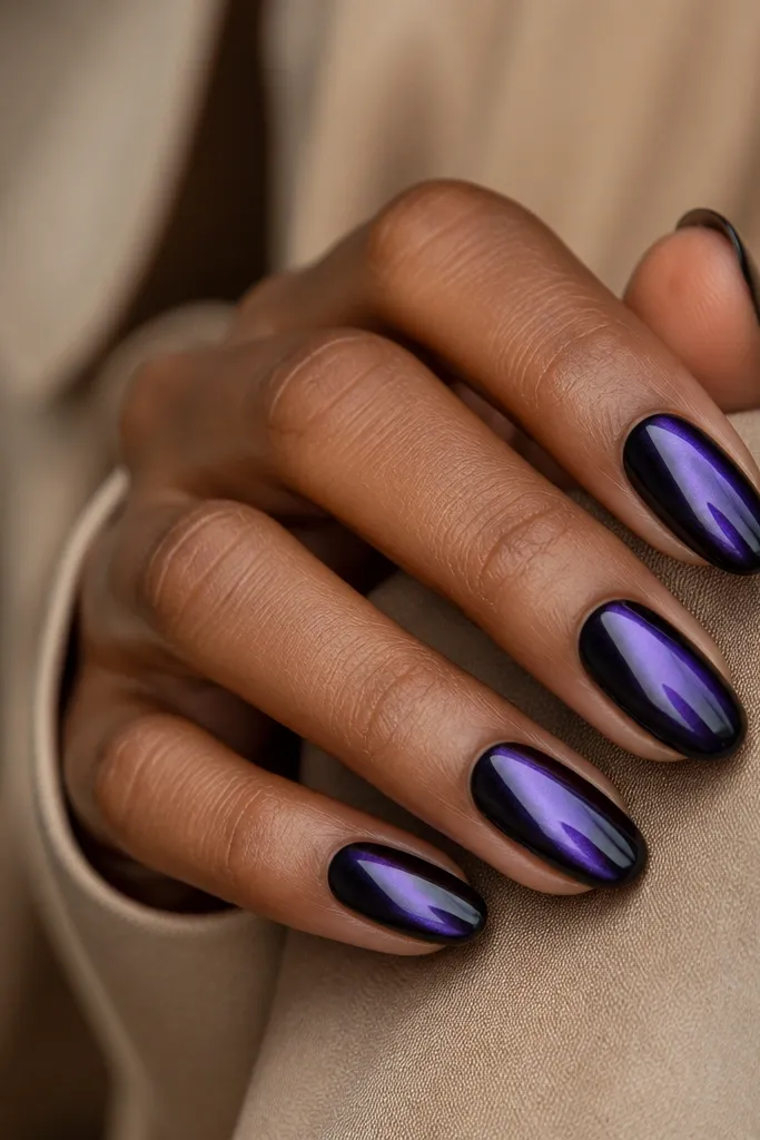 Dark purple nails with a black outline at the sides and a metallic purple chrome swipe across the center; it looks glossy and reflective.