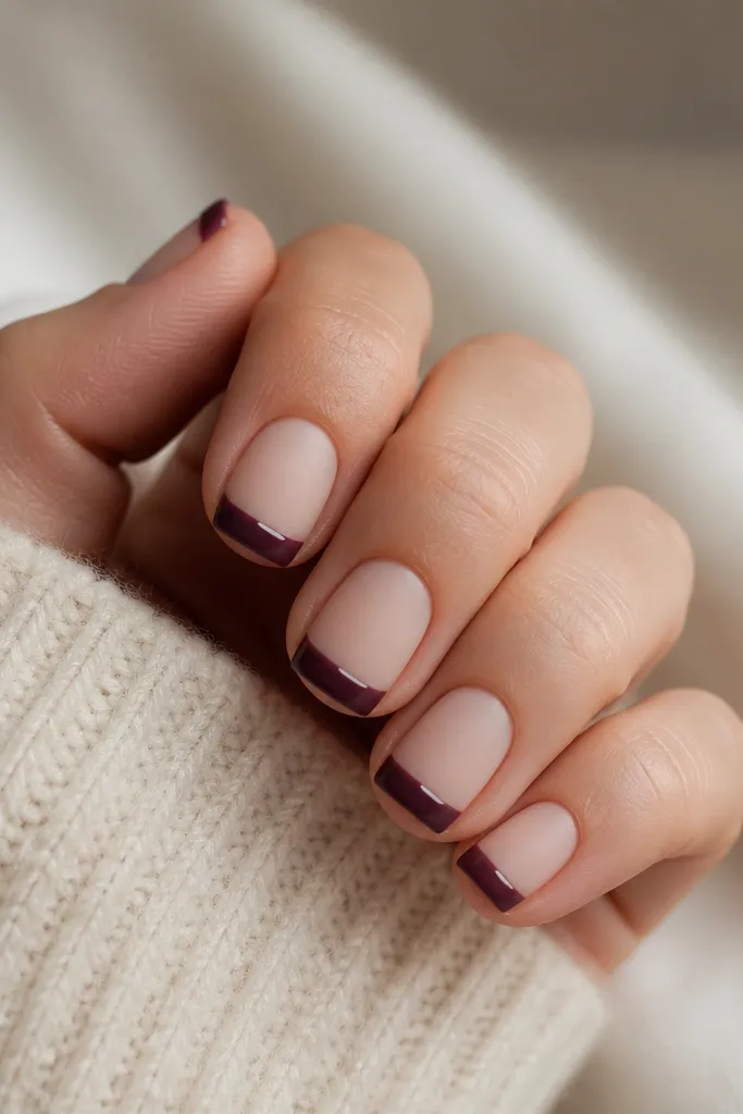 Short square nails; nude base with matte finish; dark purple French tips are matte except a thin glossy stripe inside the tip; clean lines.