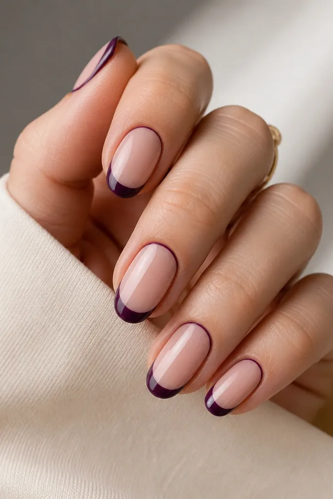 Medium oval nails with sheer nude base; dark purple French tips; a thin dark purple outline tracing the cuticle curve; glossy finish.