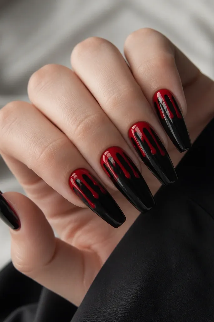Long coffin nails. Base is glossy black. At the tips, red "drip" shapes hang down from the top edge in three uneven streams per nail. The drips have a glossy, gel-like shine.