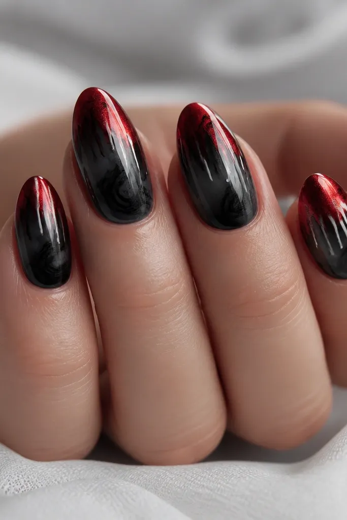 Short almond nails with a glossy black smoke gradient starting near the cuticle and fading into a chrome blood-red tip. A few thin white drips run down from the red chrome edge like dried paint, with one drip landing over a faint black swirl. The chrome catches light as a mirror finish while the smoke looks soft and cloudy.