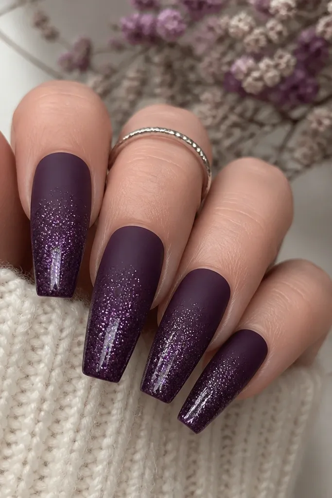 Coffin nails with matte dark purple base; glitter fade starts halfway down and increases toward the tips, with a glossy topcoat only over the glitter area.