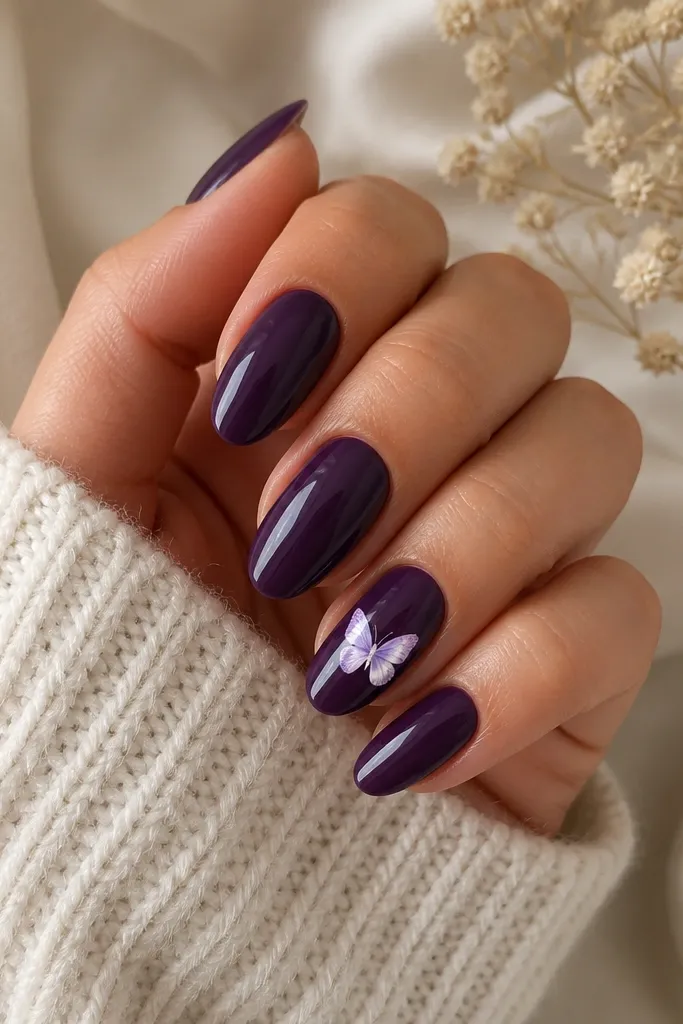 Almond nails in glossy dark purple; one accent nail has a small white butterfly decal with lavender shading near the center, other nails plain glossy.