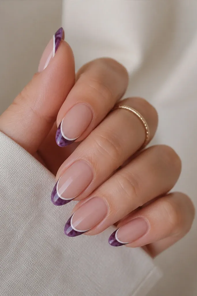 Short almond nails with a nude base; dark purple French tips shaped like a marble pattern; a thin white line outlines the outer edge of the tip.