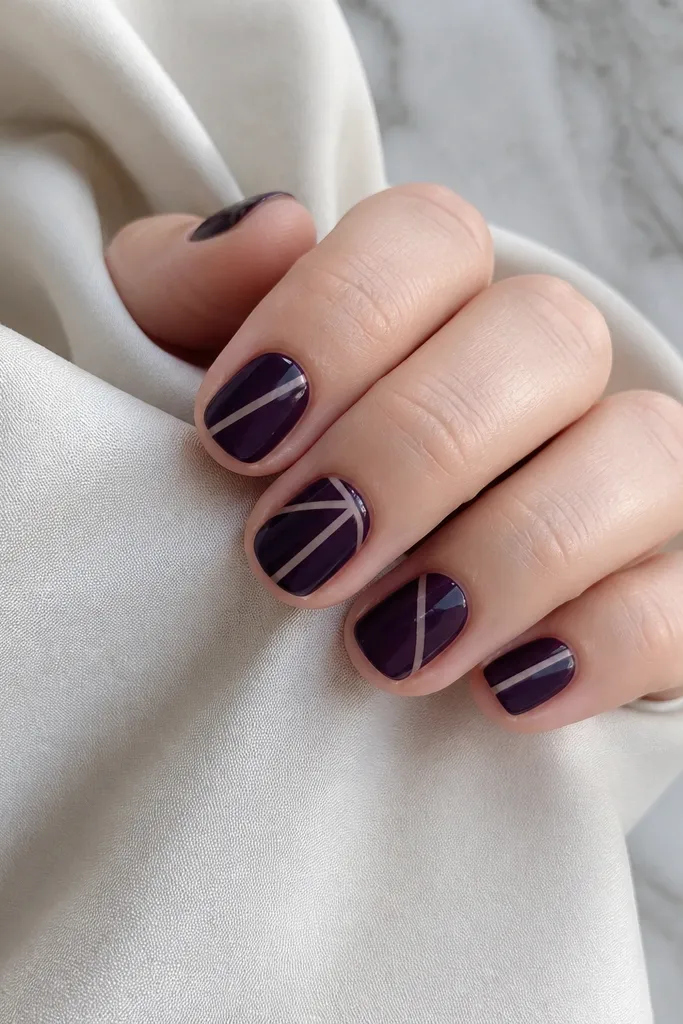 Short nails in dark purple with crisp geometric lines created by thin negative space gaps. The design uses tape-like edges for sharp angles.