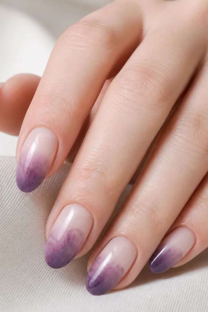 Nude nails with a watercolor wash of dark purple on the lower half. The edges are soft and feathered, like ink diluted in water. No sharp lines.
