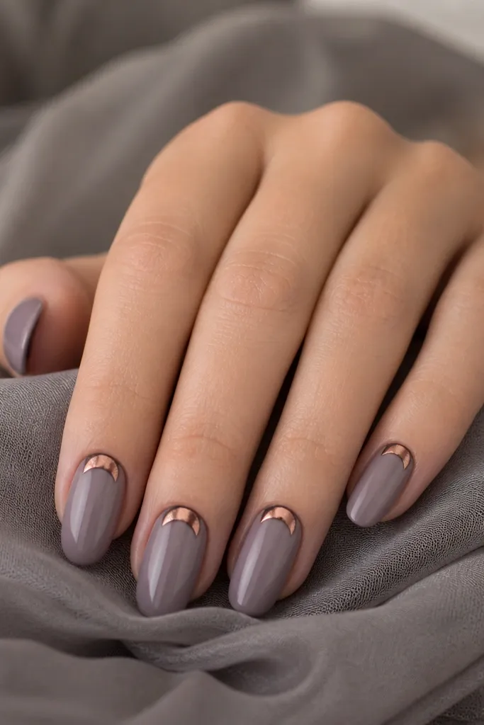 Smoky gray-lavender nails with glossy finish; each nail has a copper crescent near the cuticle, like a half-moon, with a thin copper outline.