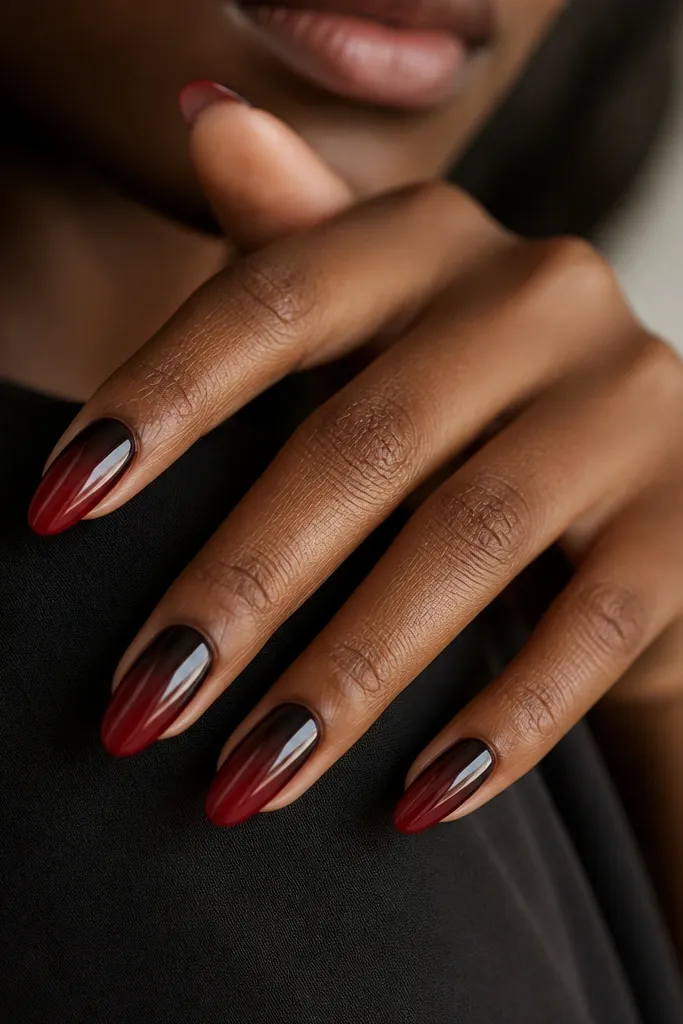 Nails show a gradient from black at the cuticle area fading into oxblood toward the tips. The gradient is smooth and glossy, with no hard line.