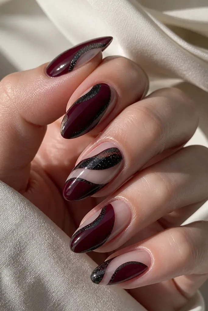 Oxblood nails with black shimmer placed in curved bands. Some areas are negative space showing the natural nail or a clear base in between the shimmer bands. The shimmer looks sparkly and dark.