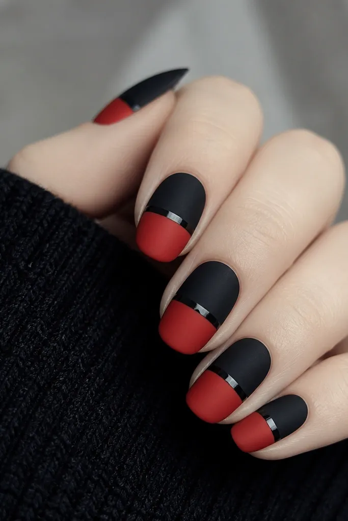 Nails split horizontally. The top half is matte black, the bottom half is matte red. A single glossy black line divides the halves at the center, shining and crisp. The nails look flat and textured except the divider line.
