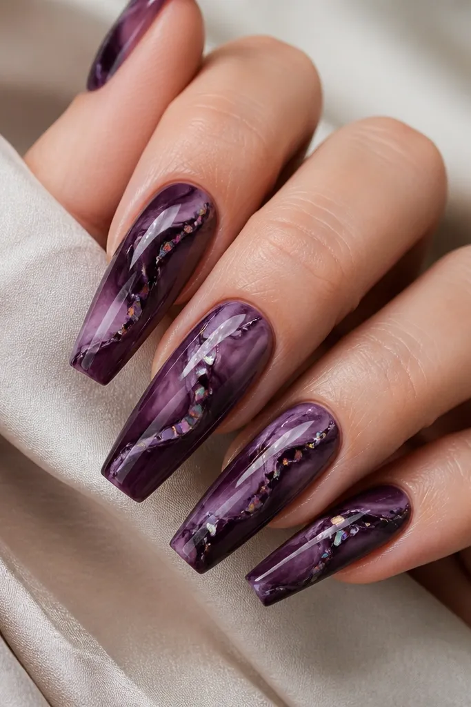 Coffin nails with aubergine marble swirls in darker and lighter purple; small irregular iridescent glitter fragments are tucked into the vein intersections, glossy finish.