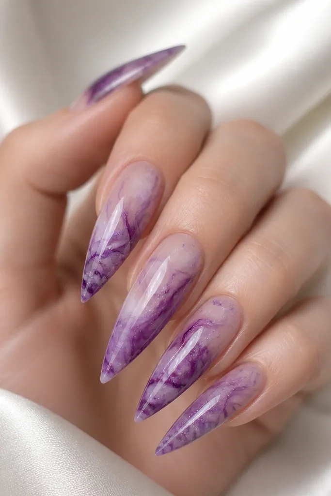 Stiletto nails with purple ink marble swirls; micro glimmer glitter specks are sprinkled lightly across the marbled areas, glossy finish.