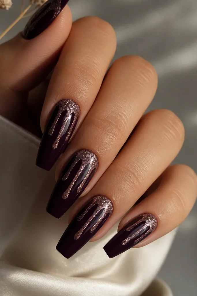 Coffin nails with plum night base; glitter forms a controlled drip pattern from the tip downward in two or three trails per nail, glossy topcoat.