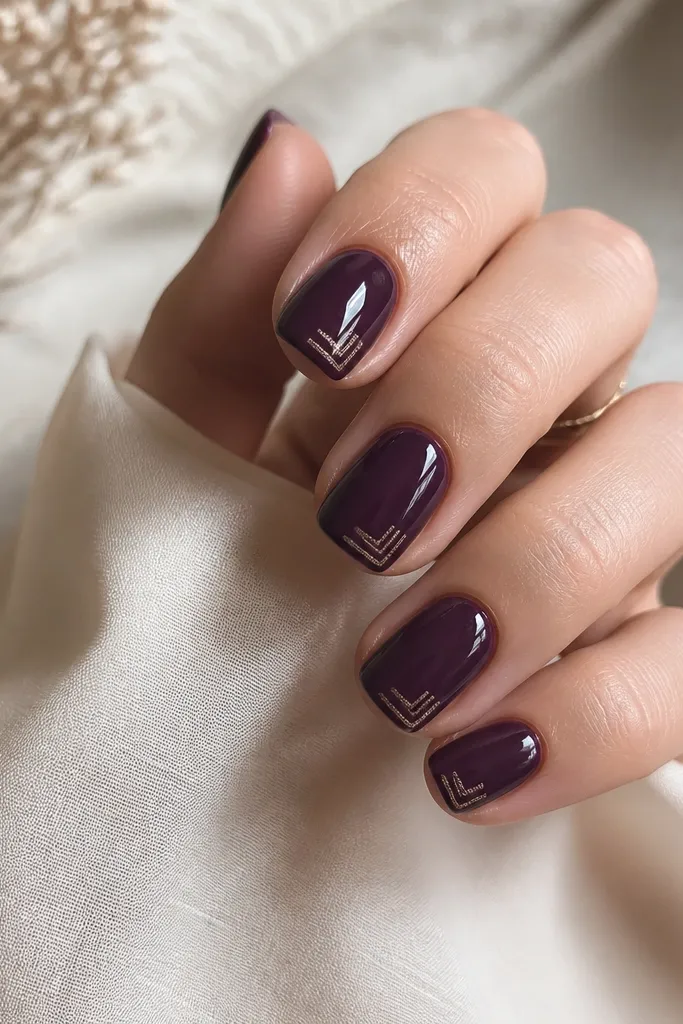 Short squoval nails in dark purple with two tiny glitter linework corners on each nail near the free edge; lines are thin and geometric, glossy finish.