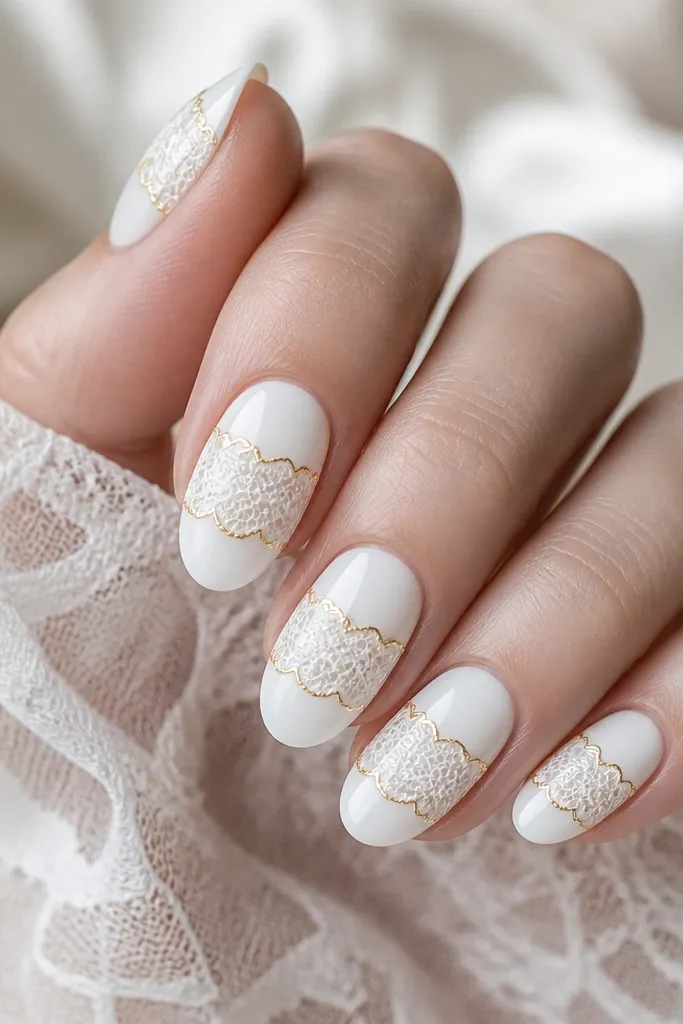 Medium oval nails with a glossy white base. On each nail, a lace-like white pattern is stamped or painted across the center, then outlined with a thin gold border around the pattern. No glitter.