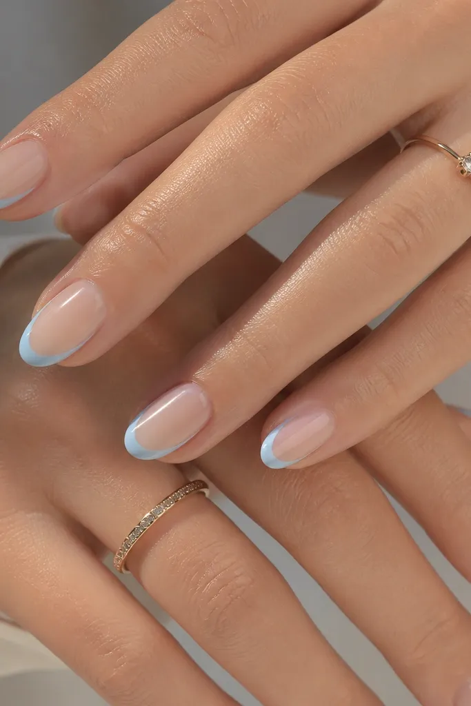 Nude base nails with baby blue French tips that include a side outline leaving nude streaks near the sidewalls. The smile curve stays thin and sharp.