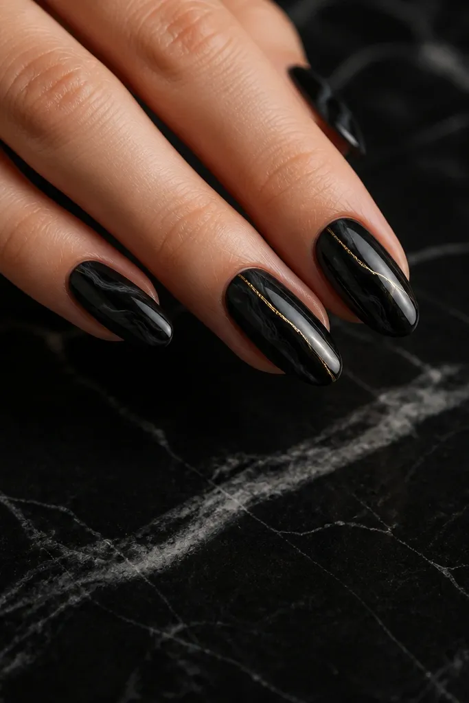Black marble background with soft gray swirl veining; a single metallic gold vein line runs diagonally from near the cuticle toward the tip on two nails.