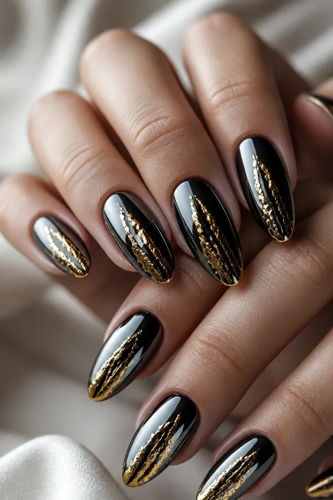 Black mirror chrome nails with a gold foil drip effect running from near the center of the nail toward the lower half, irregular and shiny.