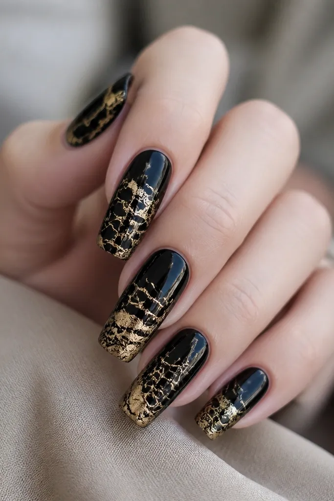 Medium coffin nails with glossy black base and a crackle-like network of gold leaf and thin lines concentrated toward the center and tip, resembling lightning or aged paint.