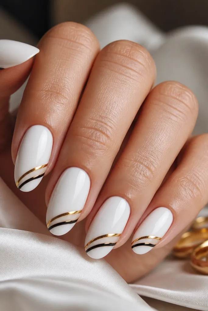 Long nails with glossy black base and a gold swirl that looks like a cuff bracelet wrapping around the lower third of each nail; the swirl has thin lines and negative space.