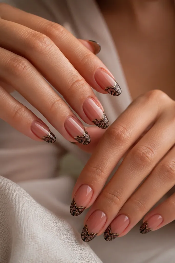 Sheer red nude nails with black lace pattern only on the tips, and a thin gold line running along the base of the lace like thread.