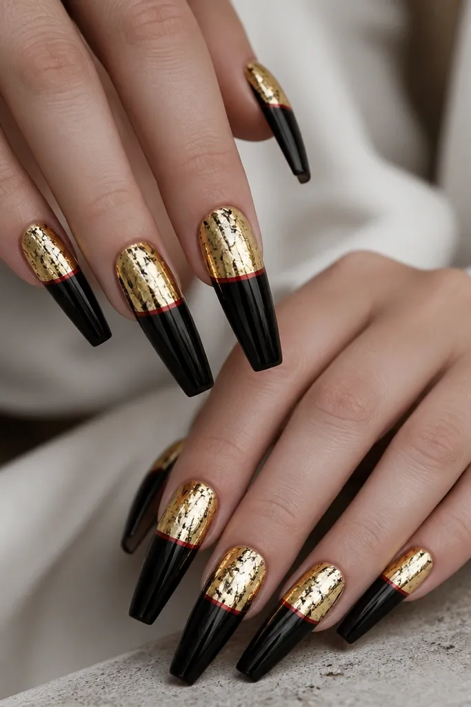 Long coffin nails with glossy black base, a gold foil half-sheet covering the upper half, and a thin red line along the gold/black boundary.