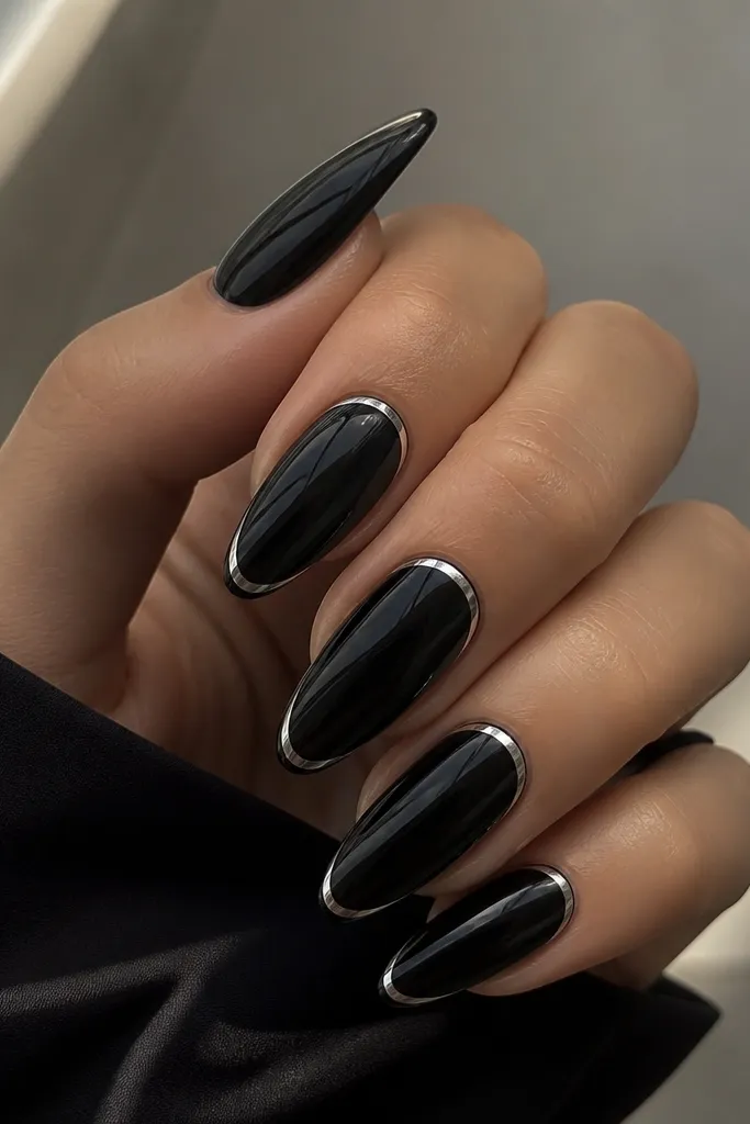 Almond nails with a glossy black jelly base. The French line is a thin silver chrome arc that stands out sharply against the dark base.
