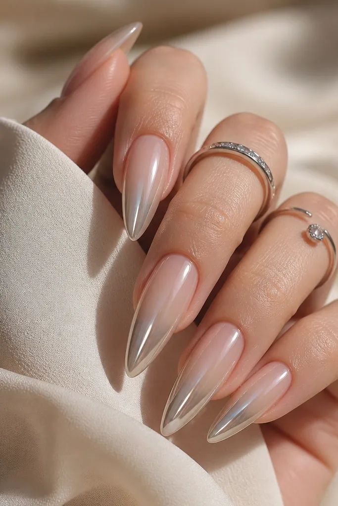 Long almond nails with nude-to-white ombré near the tip and a chrome fade that starts at the tip and softens upward.