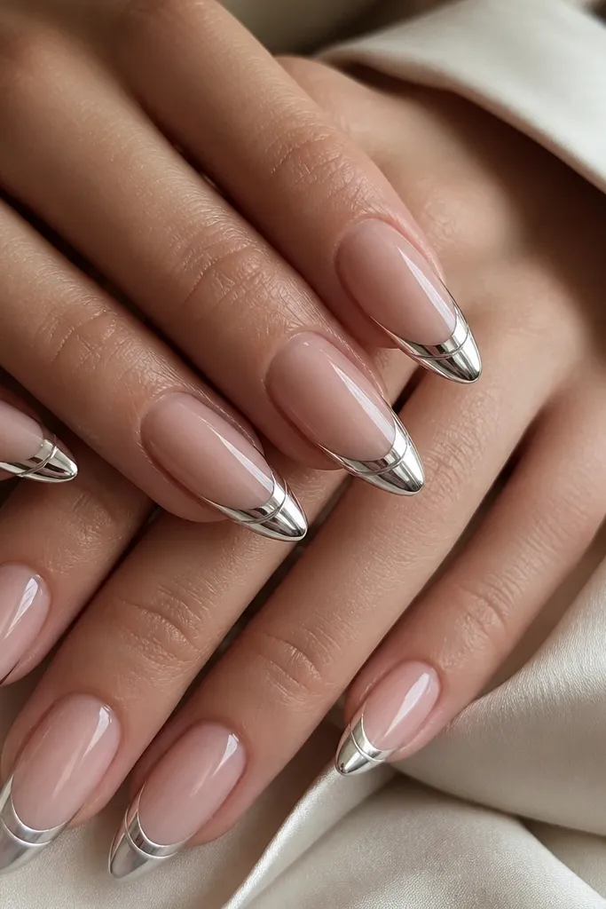 Long almond nails with nude base and chrome French tips, plus a thin diagonal chrome micro-stripe crossing the French area.