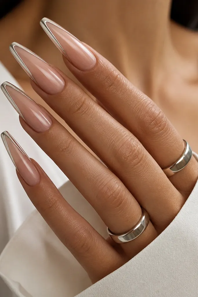 Long coffin nails with a sheer nude base. The French tip is outlined with mirror chrome along the edge, but the tip interior is left nude and only the outline is metallic.