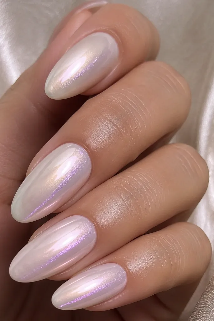 Glossy pearl base with a mostly soft sheen; micro chrome is dusted lightly near the center and along one side, creating a subtle reflective ribbon.