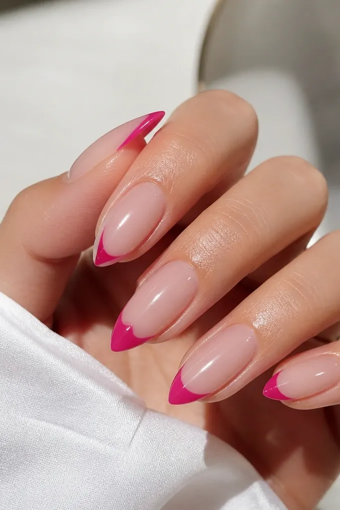 Transparent jelly nails with a glossy clear base; each nail has a hot pink tip, but the tip shapes vary slightly, creating a skittle effect across the set.