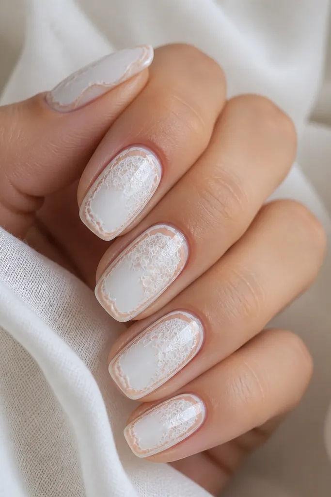 Milky white base with delicate lace-like lines across the nail; a thin peach outline frames the lace, creating a small border effect.